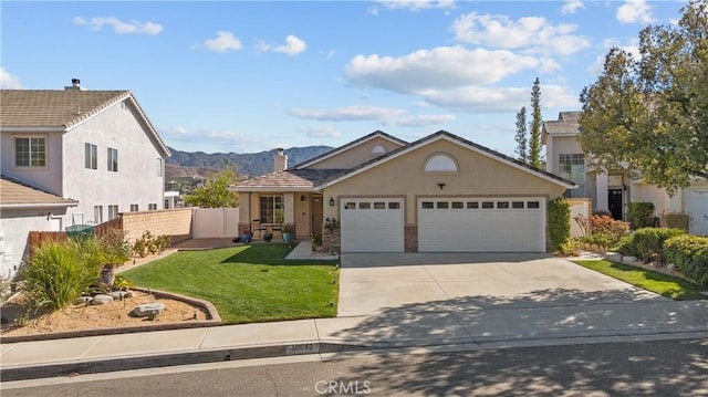 view of front facade featuring stucco siding, concrete driveway, an attached garage, a front yard, and fence