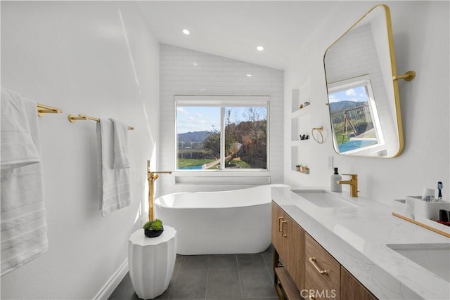 full bath with lofted ceiling, a soaking tub, a sink, and tile patterned floors