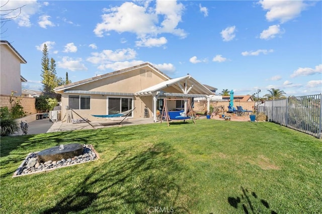 rear view of property featuring a fenced backyard, a patio, a lawn, and stucco siding