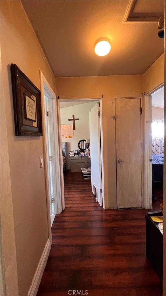 hall featuring dark wood-style floors and baseboards