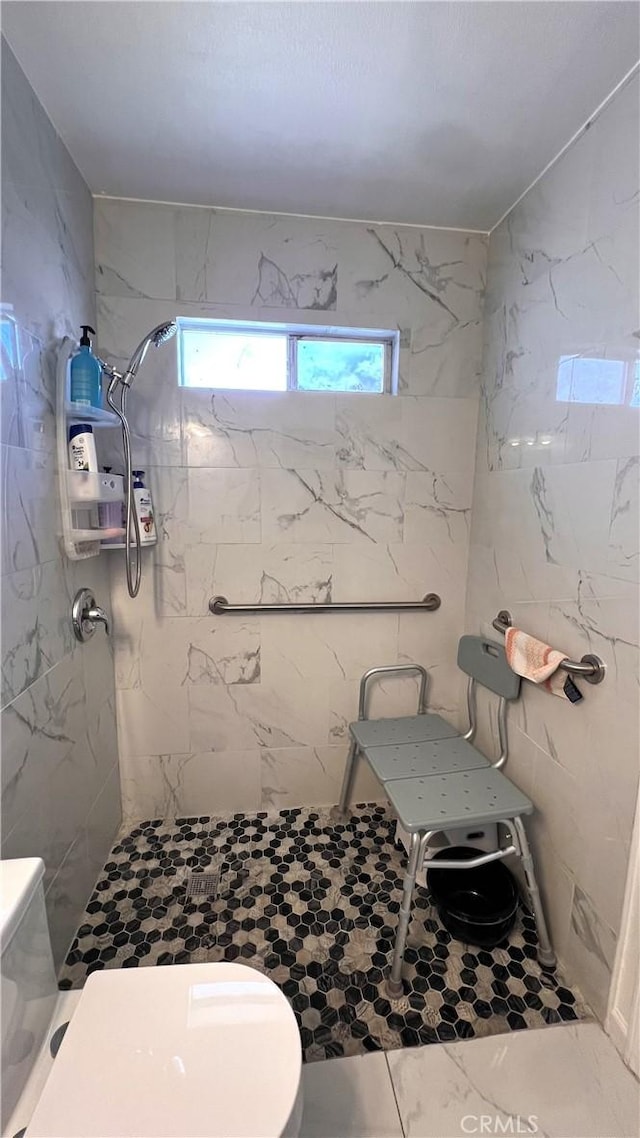 bathroom with toilet and a tile shower