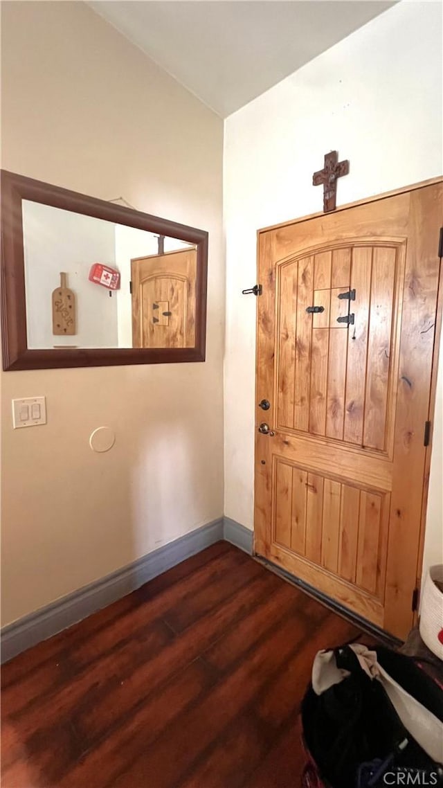 entrance foyer with dark wood-style flooring and baseboards