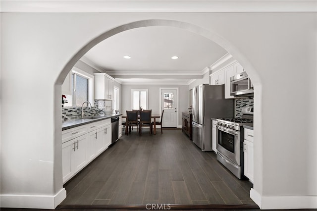 kitchen featuring dark countertops, white cabinets, stainless steel appliances, and dark wood-type flooring