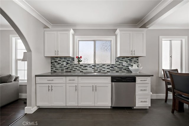 kitchen with arched walkways, stainless steel dishwasher, a sink, and ornamental molding