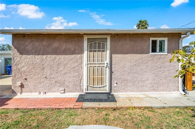 doorway to property featuring stucco siding