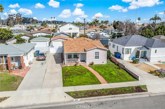 view of front of property featuring roof with shingles, a gate, a residential view, driveway, and a front lawn