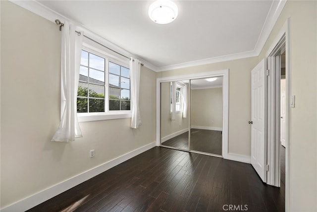 unfurnished bedroom featuring ornamental molding, a closet, dark wood finished floors, and baseboards