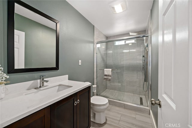 bathroom featuring a stall shower, vanity, and toilet