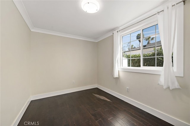 empty room featuring dark wood-style floors, crown molding, and baseboards