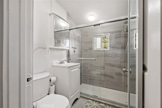 full bath with a stall shower, vanity, and toilet