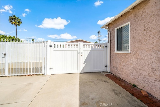 view of gate with a patio area and fence