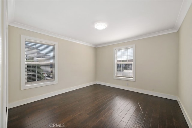 empty room featuring dark wood-style floors, crown molding, and baseboards