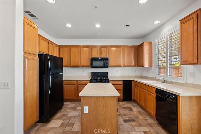 kitchen featuring a kitchen island, a sink, visible vents, light countertops, and black appliances