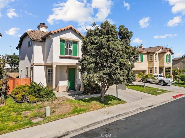 multi unit property featuring driveway, a tile roof, a chimney, fence, and stucco siding