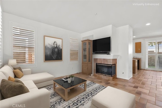 living room featuring stone finish floor, a fireplace, and recessed lighting