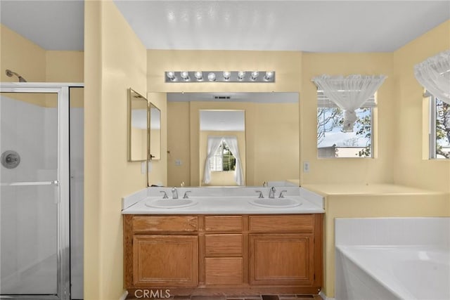 full bath featuring a stall shower, a garden tub, a sink, and double vanity