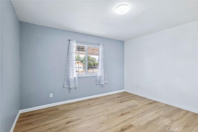 empty room featuring wood finished floors and baseboards