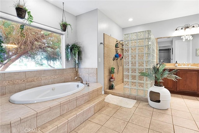 bathroom with tile patterned flooring, a walk in shower, vanity, and a bath