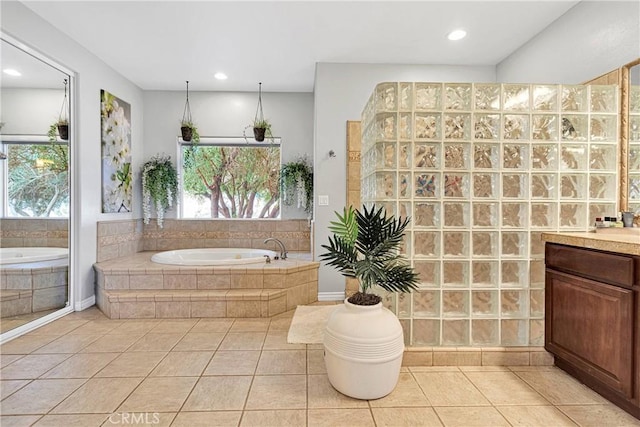 full bath featuring recessed lighting, a garden tub, vanity, and tile patterned floors