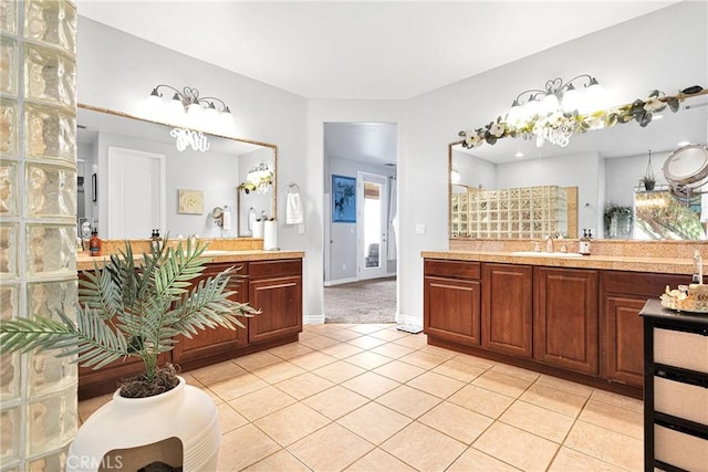 full bathroom with vanity, baseboards, a walk in shower, and tile patterned floors