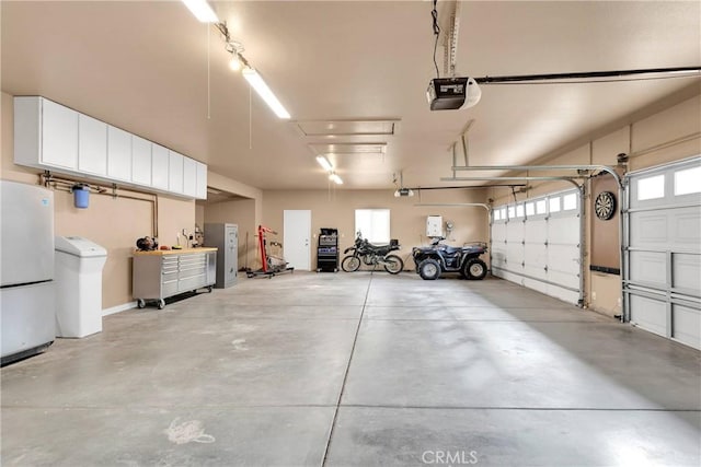 garage with a garage door opener and freestanding refrigerator