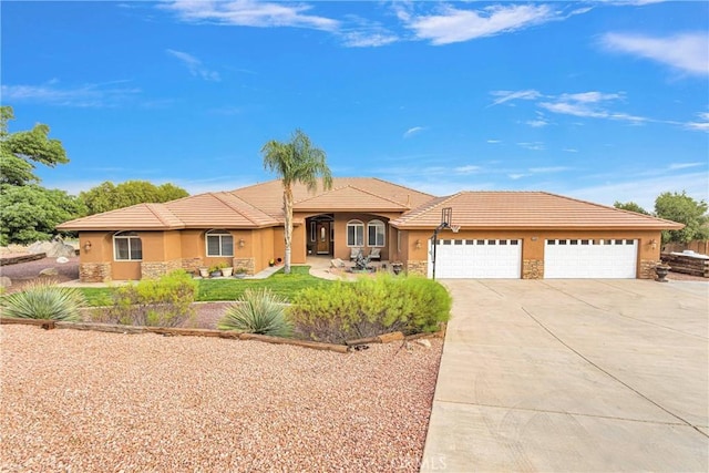 ranch-style house featuring a garage, stone siding, concrete driveway, and stucco siding