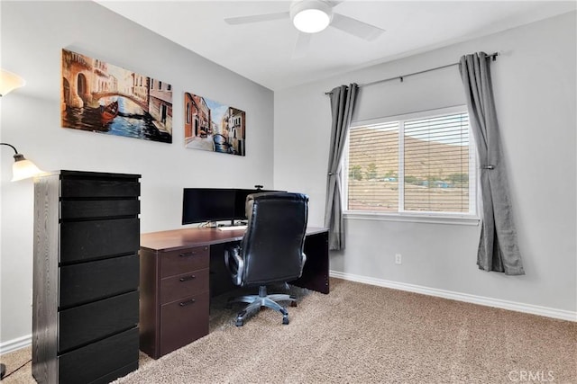 office featuring light carpet, baseboards, and a ceiling fan