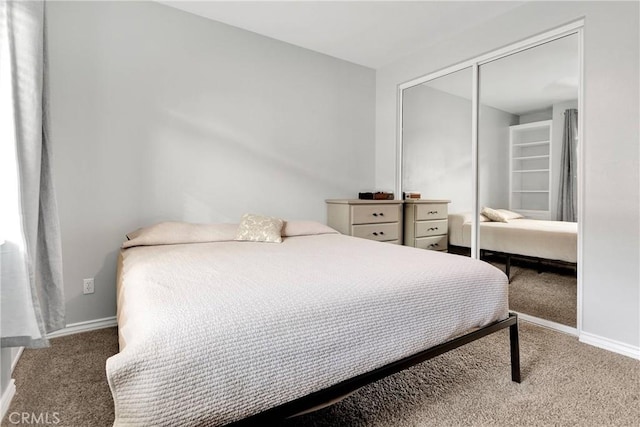 carpeted bedroom featuring a closet and baseboards