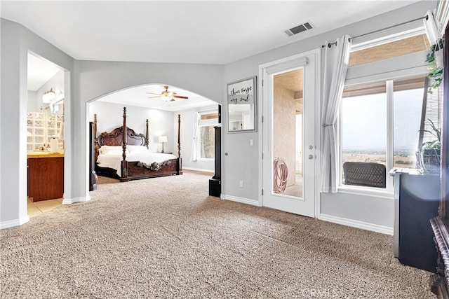 bedroom featuring arched walkways, visible vents, baseboards, vaulted ceiling, and carpet