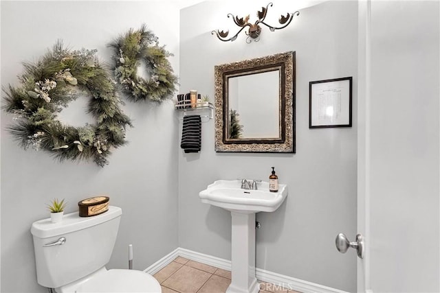 bathroom with toilet, baseboards, and tile patterned floors