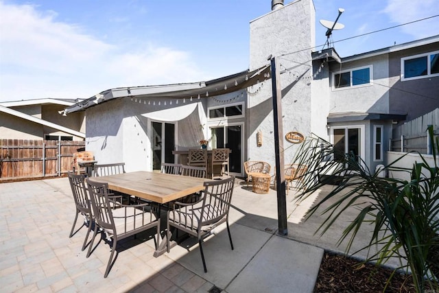 view of patio featuring fence and outdoor dining area