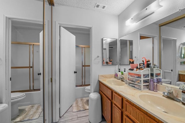 full bathroom featuring enclosed tub / shower combo, a sink, and toilet