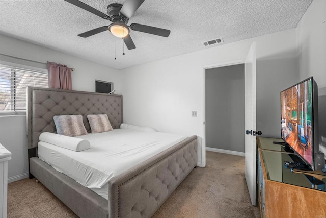 bedroom with light carpet, baseboards, visible vents, and a textured ceiling