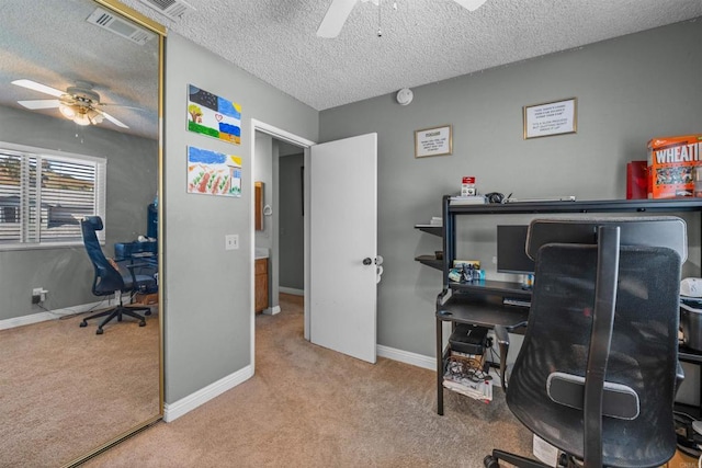 office area with visible vents, carpet floors, a textured ceiling, and a ceiling fan