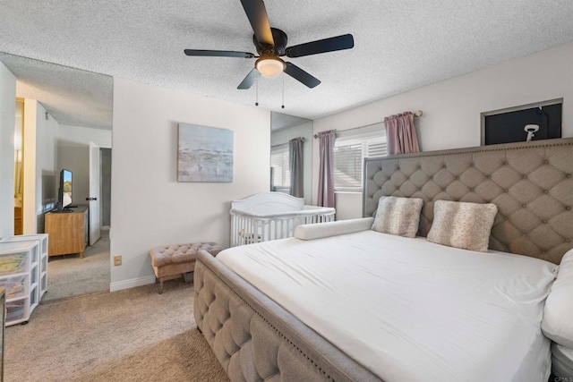 bedroom featuring ceiling fan, baseboards, a textured ceiling, and light colored carpet