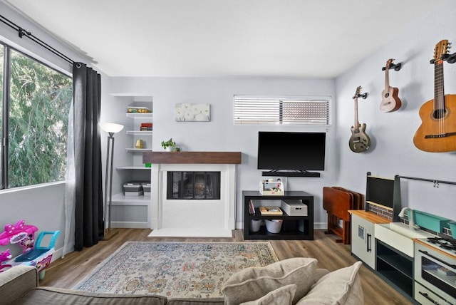 living room with a fireplace with flush hearth, wood finished floors, and baseboards