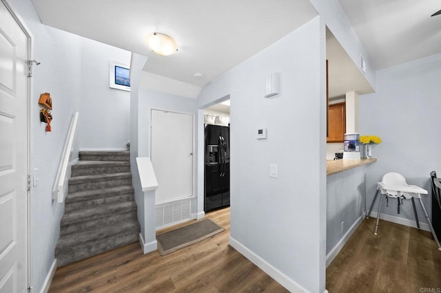 stairs with visible vents, baseboards, and wood finished floors