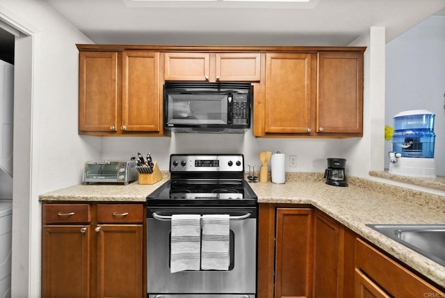 kitchen featuring black microwave, brown cabinetry, stainless steel range with electric stovetop, and a toaster