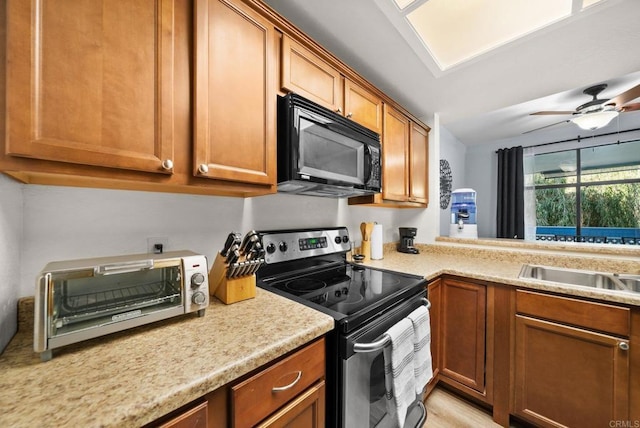 kitchen featuring black microwave, brown cabinetry, and stainless steel range with electric cooktop