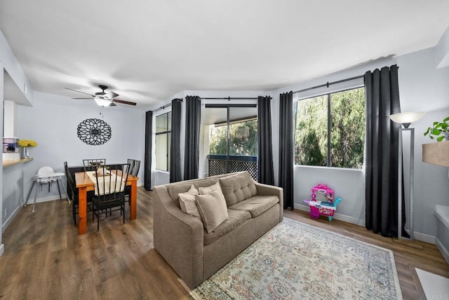 living area with ceiling fan, baseboards, and wood finished floors