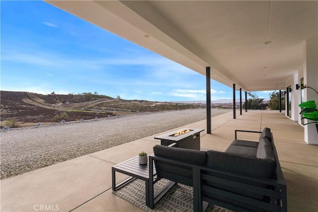 view of patio / terrace featuring a mountain view and an outdoor living space with a fire pit