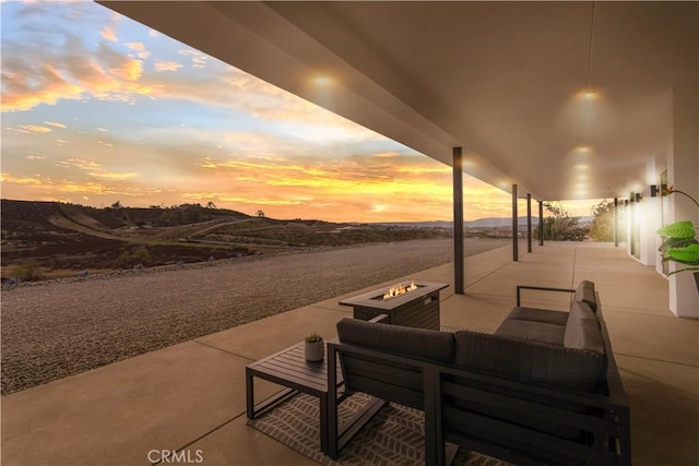 view of patio with an outdoor living space with a fire pit