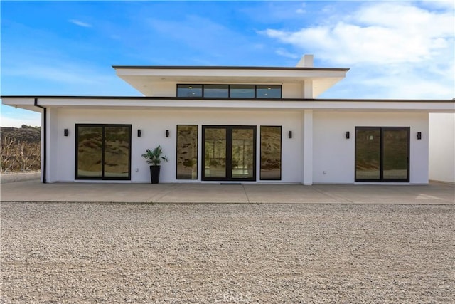 rear view of property with a patio and stucco siding