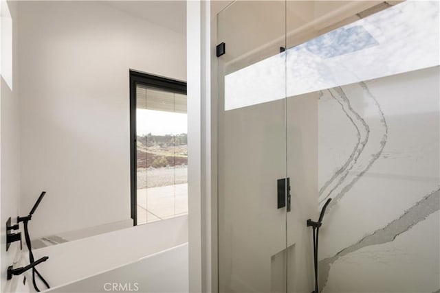 interior space with a stall shower and a washtub