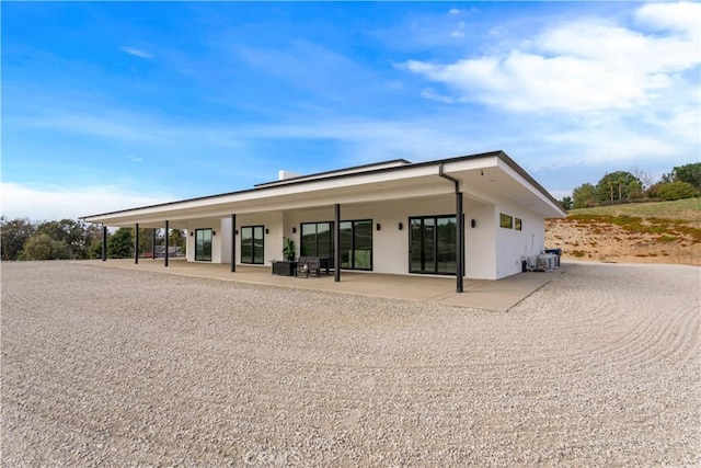 rear view of house with a patio area and stucco siding