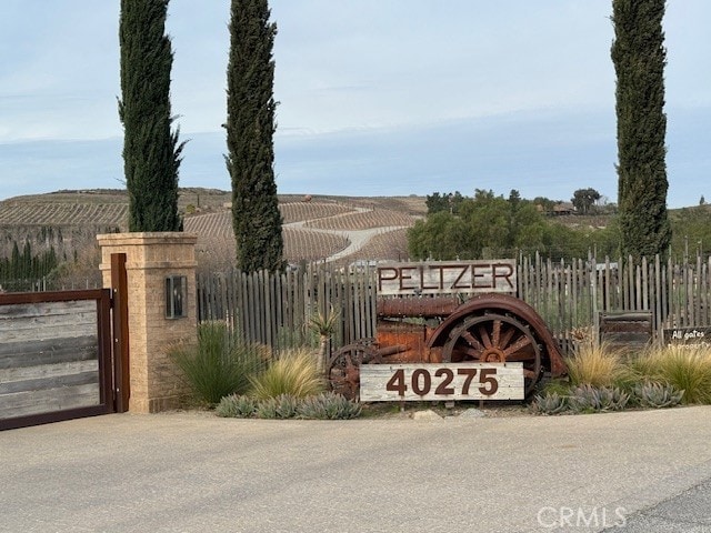 community sign featuring a gate and fence