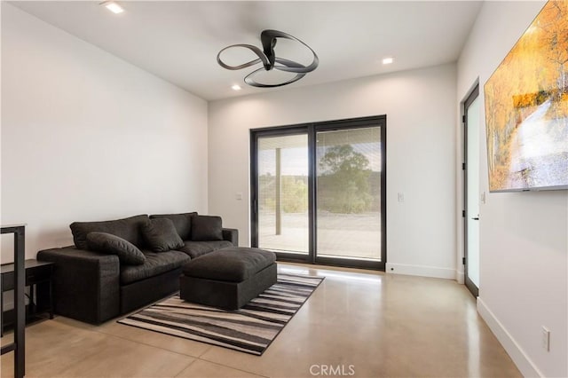 living room featuring concrete flooring, recessed lighting, and baseboards