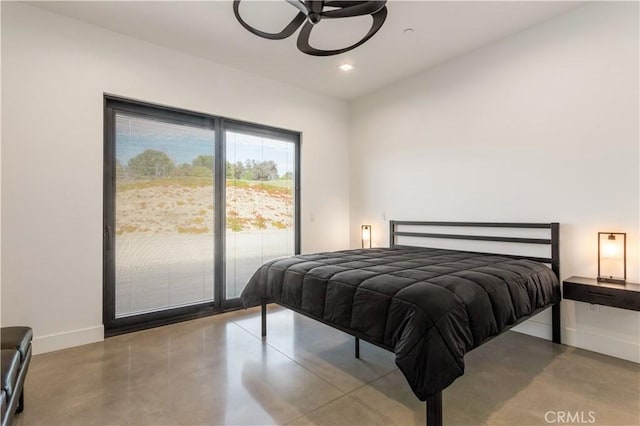 bedroom with access to exterior, finished concrete floors, baseboards, and recessed lighting