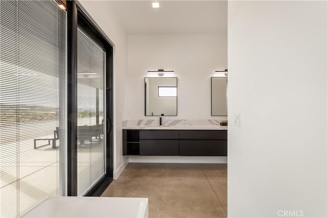 bathroom featuring concrete floors, a sink, baseboards, and double vanity