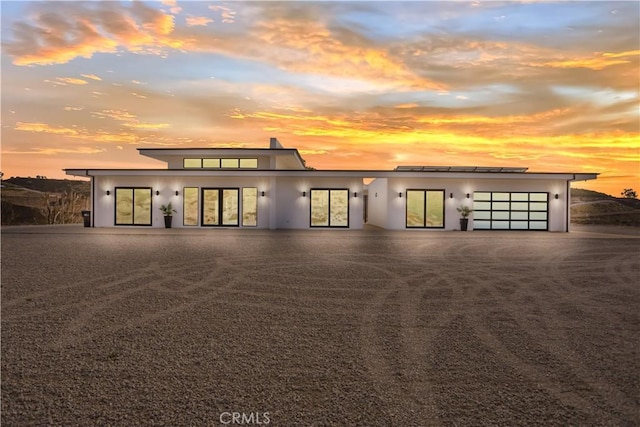 view of front of property with driveway, an attached garage, and stucco siding